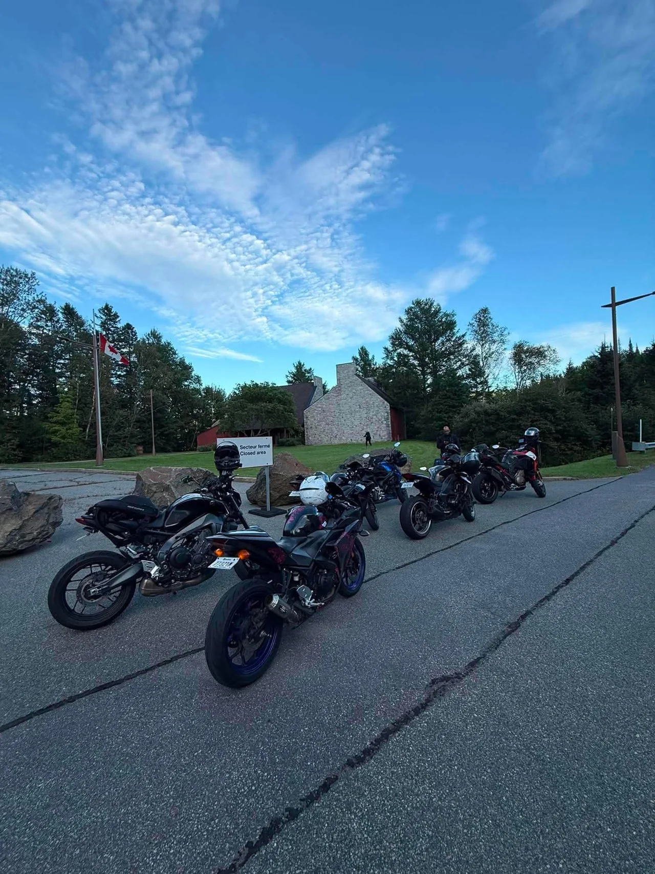 Motorcycles parked during a stop near a wooded landscape